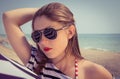 Portrait of a stylish girl in a striped t-shirt and sunglasses b Royalty Free Stock Photo