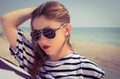 Portrait of a stylish girl in a striped t-shirt and sunglasses Royalty Free Stock Photo