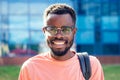 Portrait stylish and handsome African student American man in glasses smiling toothy professor on the street Royalty Free Stock Photo