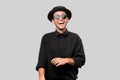 Portrait of a stylish man in a black shirt, pork pie hat and sun glasses over grey background Royalty Free Stock Photo