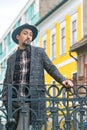 Portrait of a stylish handsome young man with a coat outdoors. A serious man wearing a coat, hat and a shirt looking confident at