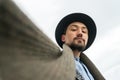 Portrait of a stylish handsome young man face wearing a coat outdoors. Low angle view of a man wearing a coat and a scarf looking Royalty Free Stock Photo