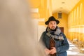 Portrait of a stylish handsome young man with a scarf outdoors. A serious man wearing a scarf, hat and a denim jacket looking