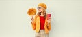 Portrait stylish happy smiling woman with yellow maple leaves, coffee cup in french beret posing over gray wall Royalty Free Stock Photo