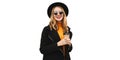 Portrait of stylish happy smiling young woman with cup of coffee wearing black coat, round hat isolated on white background Royalty Free Stock Photo