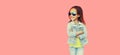 Portrait of stylish little girl child wearing sunglasses, jeans jacket on pink background Royalty Free Stock Photo