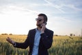 Portrait of stylish male with cellphone summer wheat field Royalty Free Stock Photo