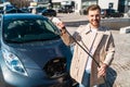 Portrait of stylish man with electric car charging connector in hands. Royalty Free Stock Photo