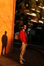 Portrait of stylish man in sporty clothes on sunset city background pose to camera Young man on urban street Royalty Free Stock Photo