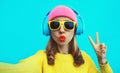 Portrait of stylish modern cool happy young woman taking selfie with mobile phone listening to music in wireless headphones Royalty Free Stock Photo