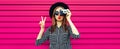 Portrait of stylish modern young woman photographer with film camera blowing her lips on pink background Royalty Free Stock Photo