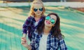 Portrait stylish mother and child wearing a sunglasses, shirts in a city park Royalty Free Stock Photo