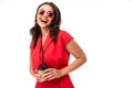 Portrait of stylish smiling girl in sunglasses and a red dress with a glass on a white background Royalty Free Stock Photo