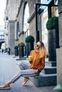 Portrait of stylish smiling happy blond woman walking in street with backpack, attractive, sunny, summer fashion trend, traveler, Royalty Free Stock Photo