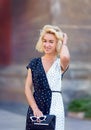 portrait of stylish smiling happy blond woman walking in street , curly hair, attractive, sunny, summer fashion trend, traveler, Royalty Free Stock Photo