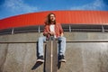 Portrait of stylish smiling hipster male skateboarder enjoying good training Royalty Free Stock Photo