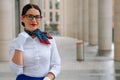 Portrait of a stylish smiling stewardess in a blue skirt with a white blouse. Mysterious girl in a business suit looks away Royalty Free Stock Photo