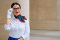 Portrait of a stylish smiling stewardess in a white Shirt blouse with a handkerchief around his neck. Mysterious girl in a Royalty Free Stock Photo
