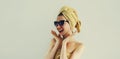 Laughing woman with wrapped towel on her head having fun in trendy sunglasses