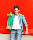 Portrait stylish teenager boy wearing a checkered shirt with skateboard in city