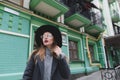 Portrait of a stylish woman in glasses and hats on the background of the architecture of the old town. Royalty Free Stock Photo