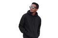 Portrait of stylish young african man looking away wearing black hoodie, sunglasses isolated on white background Royalty Free Stock Photo