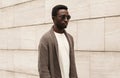 Portrait stylish young african man model looking away wearing a knitted cardigan isolated on a city street background Royalty Free Stock Photo