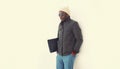 Portrait of stylish young african man posing wearing winter jacket with bag on white background Royalty Free Stock Photo