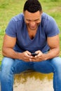 Stylish young african man sitting outside and using mobile phone Royalty Free Stock Photo