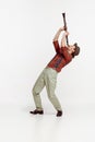 Portrait of stylish young man in red checkered shirt and hat playing clarinet isolated over white background. Classic