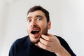 Portrait of a stylish young man scratches his beard and screams in pain. Royalty Free Stock Photo