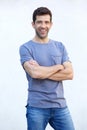 Stylish young man standing with arms crossed against white background Royalty Free Stock Photo