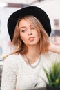 Portrait of a stylish young woman in an elegant black hat with a natural make-up with blue eyes and a shiny necklace Royalty Free Stock Photo