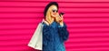 Portrait of stylish young woman with shopping bags and smartphone using voice command recorder, assistant or takes calling in city Royalty Free Stock Photo