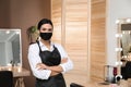 Portrait of stylist with protective mask in salon. Beauty services during Coronavirus quarantine