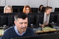 Succesful businessman foreground in busy open plan office Royalty Free Stock Photo