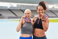 Portrait, success medals and women at stadium after winning running race or sports event outdoors. Fitness, winner and