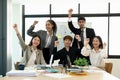 Portrait success and team work concept. Group of business partners with raised up hands in light modern workstation Royalty Free Stock Photo