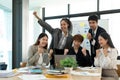 Portrait success and team work concept. Group of business partners with raised up hands in light modern workstation Royalty Free Stock Photo