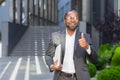Portrait of successful african american man outside office building, man in suit and glasses standing and looking at Royalty Free Stock Photo