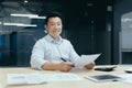 Portrait of successful Asian businessman, man smiling and looking at camera broker doing paperwork Royalty Free Stock Photo