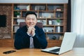 Portrait of a successful Asian businessman, man working in the office sitting at the table, looking at the camera and smiling, Royalty Free Stock Photo