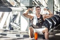 Portrait of successful athlete handsome masculine man sitting during treadmill exercise in gym, tired sportsman drinking water in Royalty Free Stock Photo