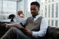 Successful black businessman drinking whiskey in office and reading documents Royalty Free Stock Photo