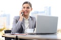 Portrait of successful business woman talking on the phone and smiling while working in the modern cafe Royalty Free Stock Photo