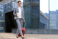 Portrait of successful business woman traveling with case at airport. Beautiful stylish female travel with luggage Royalty Free Stock Photo