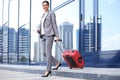 Portrait of successful business woman traveling with case at airport. Beautiful stylish female travel with luggage Royalty Free Stock Photo