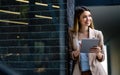 Portrait of a successful business woman using digital tablet in front of modern business building Royalty Free Stock Photo