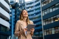 Portrait of a successful business woman using digital tablet in front of modern business building Royalty Free Stock Photo