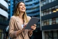 Portrait of a successful business woman using digital tablet in front of modern business building Royalty Free Stock Photo